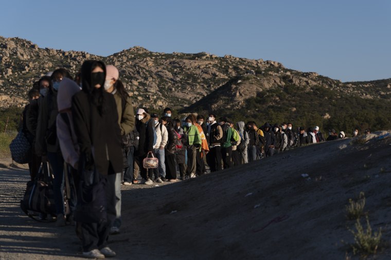 Migrantes esperan a ser procesados en la frontera de México y California, en Hot Springs, el 8 de mayo de 2024.