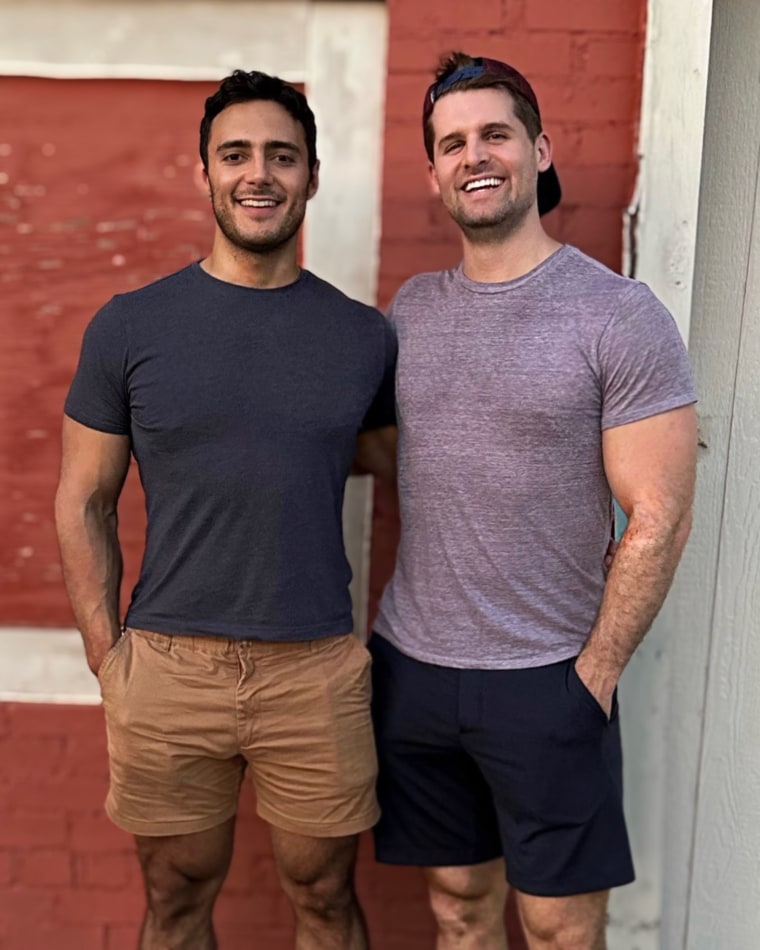 Steven Romo standing happily next to his husband