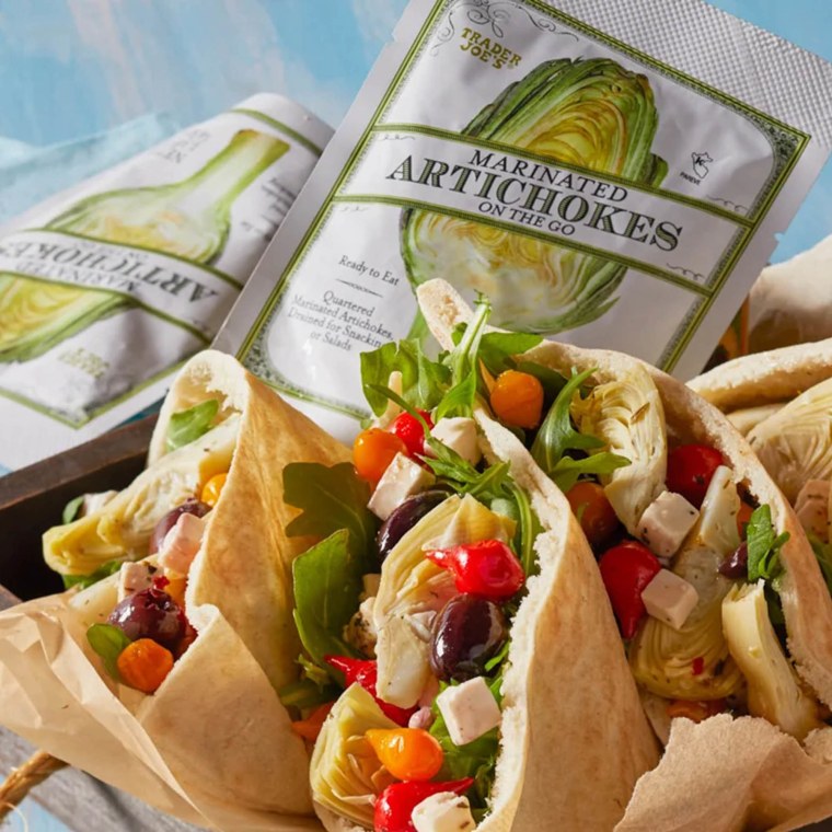 Trader Joe's Marinated Artichokes On The Go mixed with antipasto and stuffed in pita pockets, on a blue surface