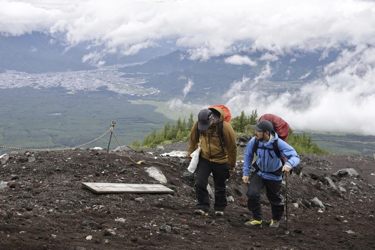 Park rangers on Japan’s sacred Mount Fuji officially started this year’s climbing season about 90 minutes before sunrise on Monday, levying new trail fees and limiting hiker numbers to curb overcrowding.