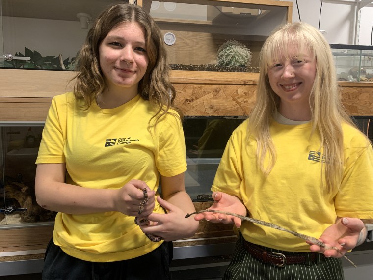 Evie Allen, level 2 student, and Ashleigh Nicole, learning assistant, hold one of the baby snakes and a snake skin.