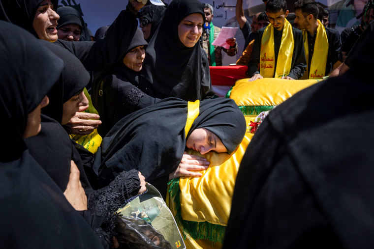 A woman mourns over a coffin.