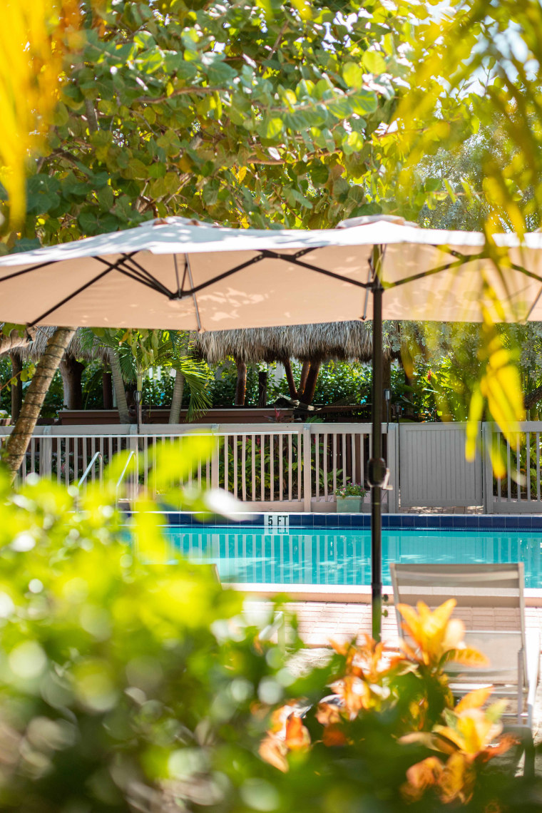 Crane's Beach House Boutique Hotel Luxury Villas pool with umbrellas and foliage in Delray Beach, Fla.