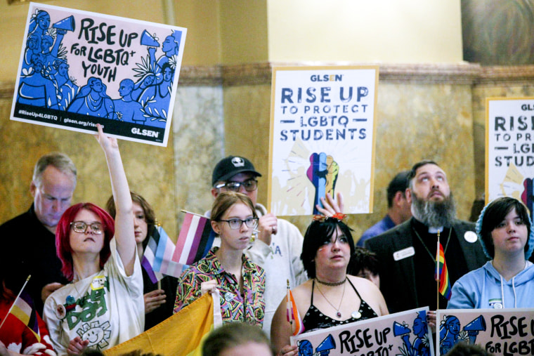 Kansas advocates rally with signs for transgender rights.
