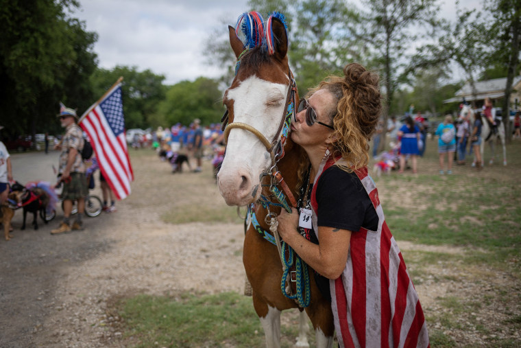 Resident kisses horse ahead of pet parade during Independence Day celebrations in Bandera, Texas