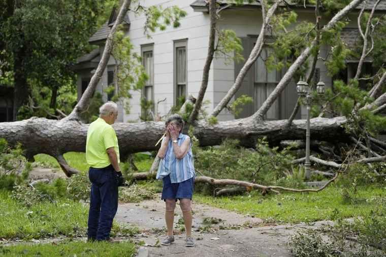 Jackie Jecmenek, right, talks with city worker Bobby Head as she stands in front of her neighbor's home in Bay City, Texas. 