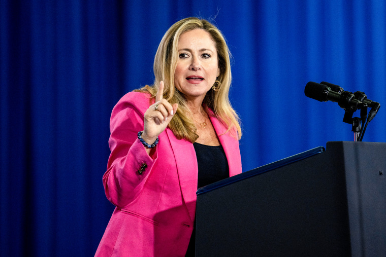 Debbie Mucarsel-Powell fala em um pódio no palco e levanta um dedo