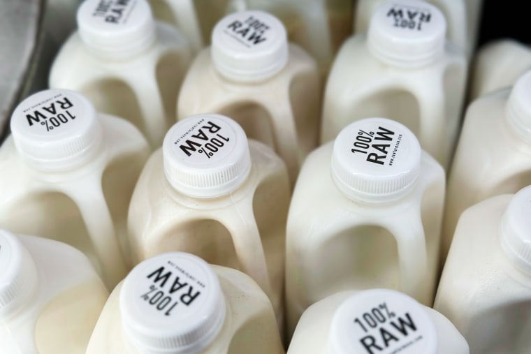 Close up of the tops of bottles of raw milk, the caps say "100% Raw"