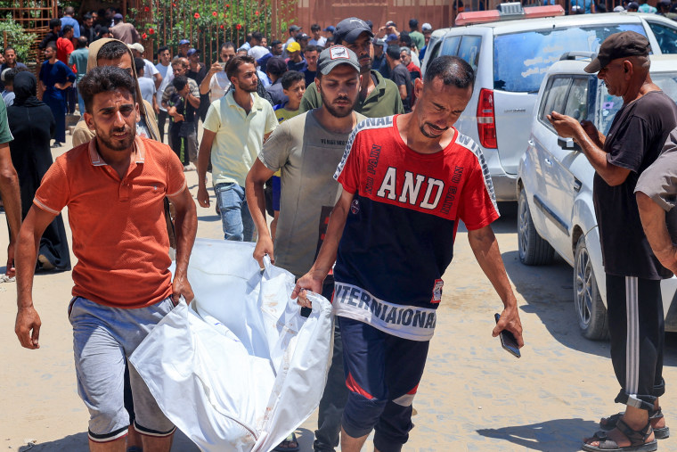 Palestinians carry away the body of a victim.