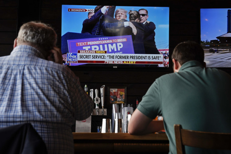 People sit in a local bar near the Fiserv Forum watching news ahead of the 2024 Republican National Convention in Milwaukee on Saturday.