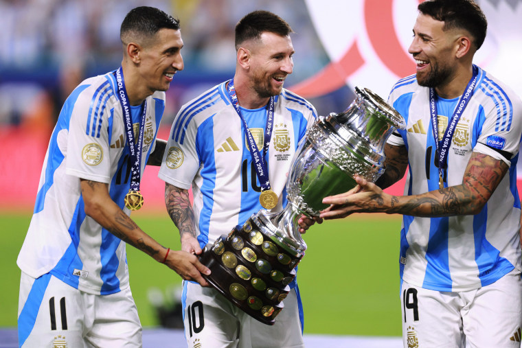 Angel Di Maria, Lionel Messi and Nicolas Otamendi of Argentina celebrate with the trophy