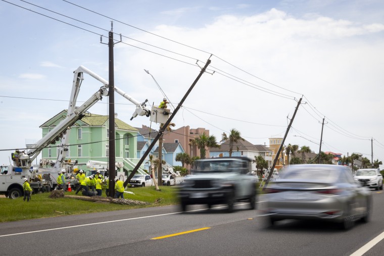 Linemen replace leaning wooden poles along on Galveston Island in Texas on Saturday, July 13, 2024.