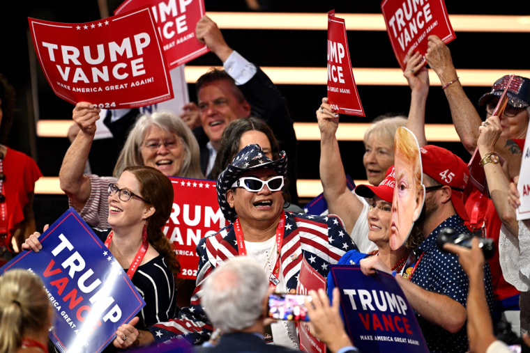 Attendees hold Trump-Vance signs during the second day of the 2024 Republican National Convention at the Fiserv Forum on July 16, 2024 in Milwaukee, Wisconsin. 