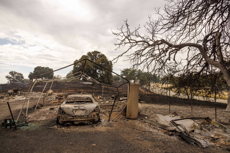 Vehicle sits destroyed by the Apache Fire as it burns in Palermo, Calif.