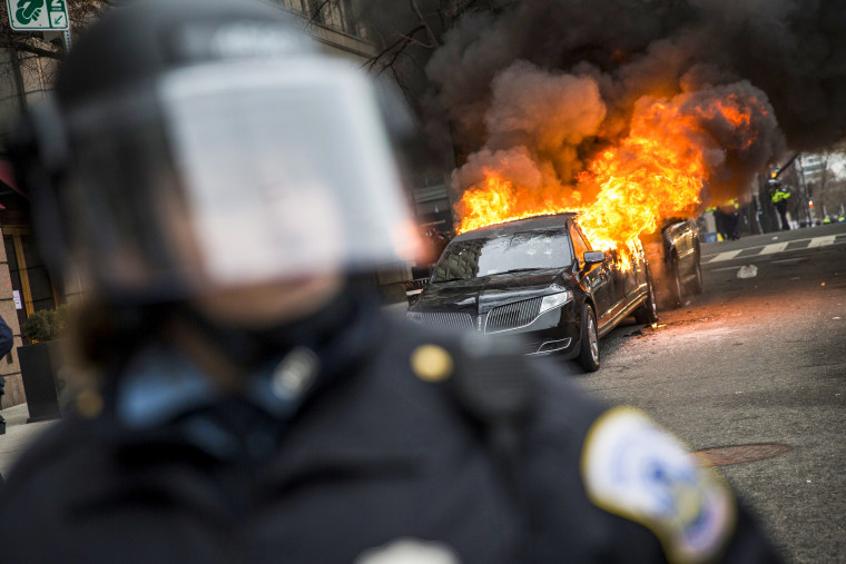 Anti-Trump protestors set a limousine on fire.