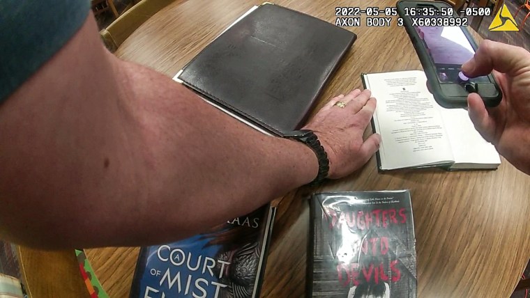 Body cam footage from senior deputy constable Scott London photographing library books 