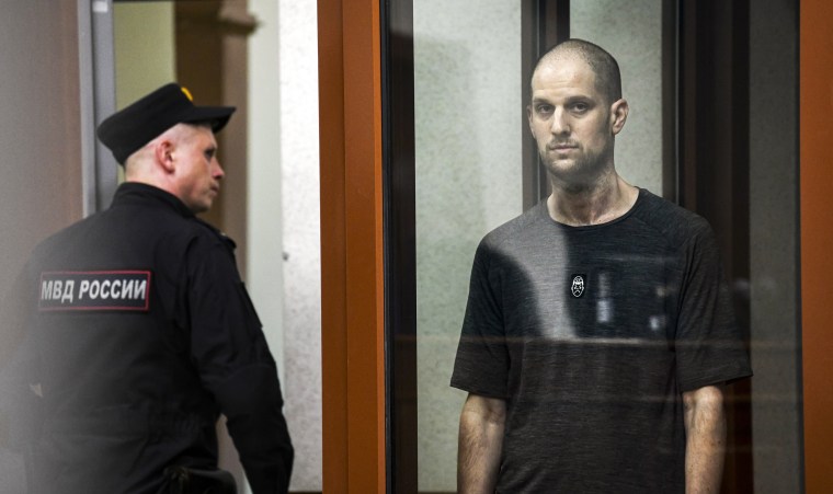 Evan Gershkovich stands listening to the verdict in a glass cage of a courtroom inside the building of "Palace of justice," in Yekaterinburg, Russia