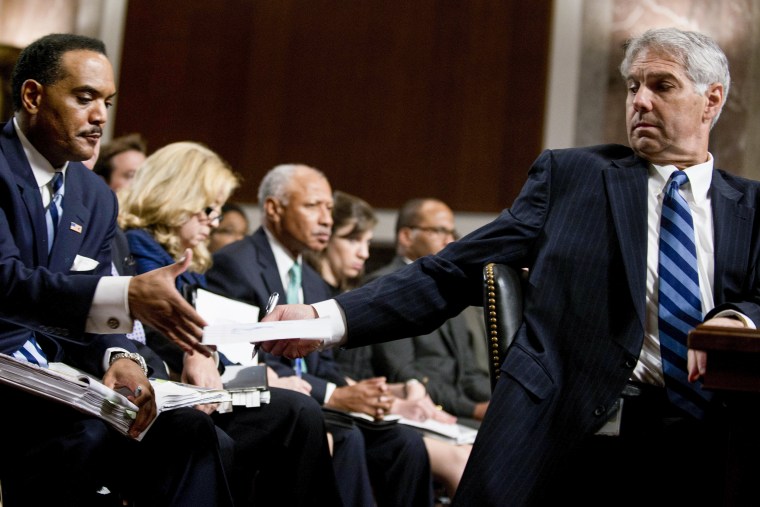 Mark Sullivan, Director of the United States Secret Service, hands a note to staff.