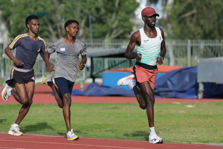 Jamal Abdelmaji, right, with fellow runners on the track