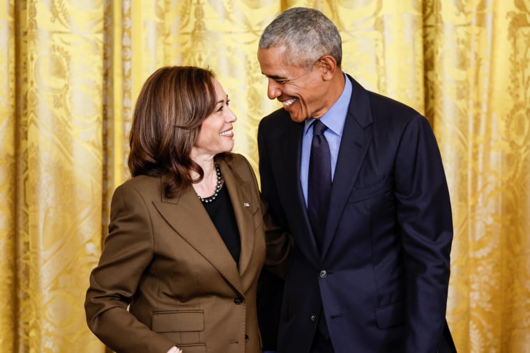 From left, Kamala Harris and Barack Obama stand side by side and smile at each other