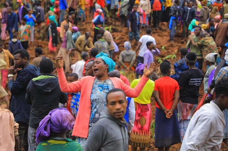 People standing at the bottom of a landslide that occurred in the Geze-Gofa district. 