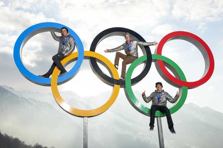 Gus Kenworthy, Joss Christensen and Nicholas Goepper posing on Olympic rings after winning Men's Ski Slopestyle medals at Rosa Khutor Plateau Olympic Village.