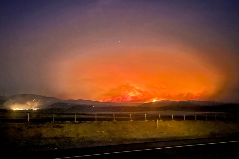 The Durkee fire burns in the background near Huntington, Ore., on Tuesday.