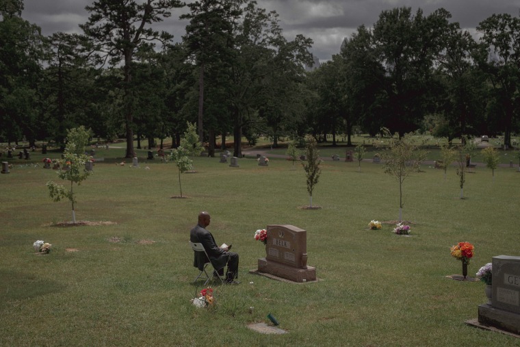 Terry Belk sits in front of his wife's grave site