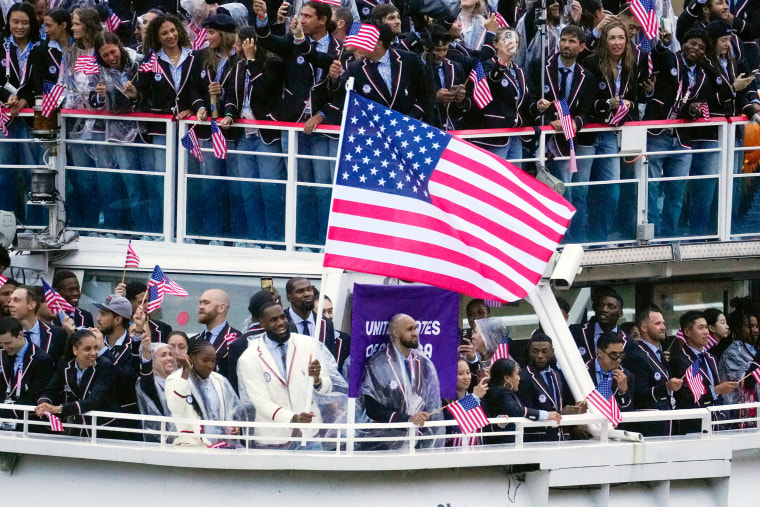 O barco que transporta a seleção dos Estados Unidos, com Lebron James carregando a bandeira, desce o rio Sena, em Paris, durante a cerimônia de abertura dos Jogos Olímpicos de Verão de 2024, na sexta-feira.