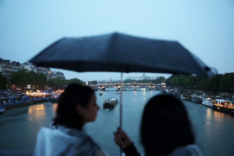 Spectators shelter from the rain during the opening ceremony of the Olympic Games Paris 2024 on July 26, 2024 in Paris, France.