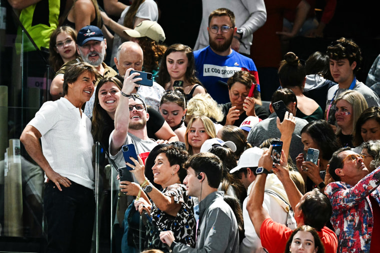 Tom Cruise takes selfies with fans during the artistic gymnastics women's qualification at the Paris 2024 Olympic Games at the Bercy Arena in Paris, on July 28, 2024.