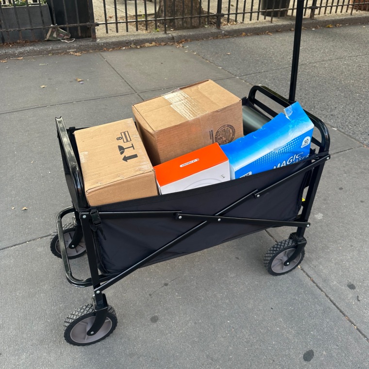 Foldable wagon packed with boxes on the sidewalk.