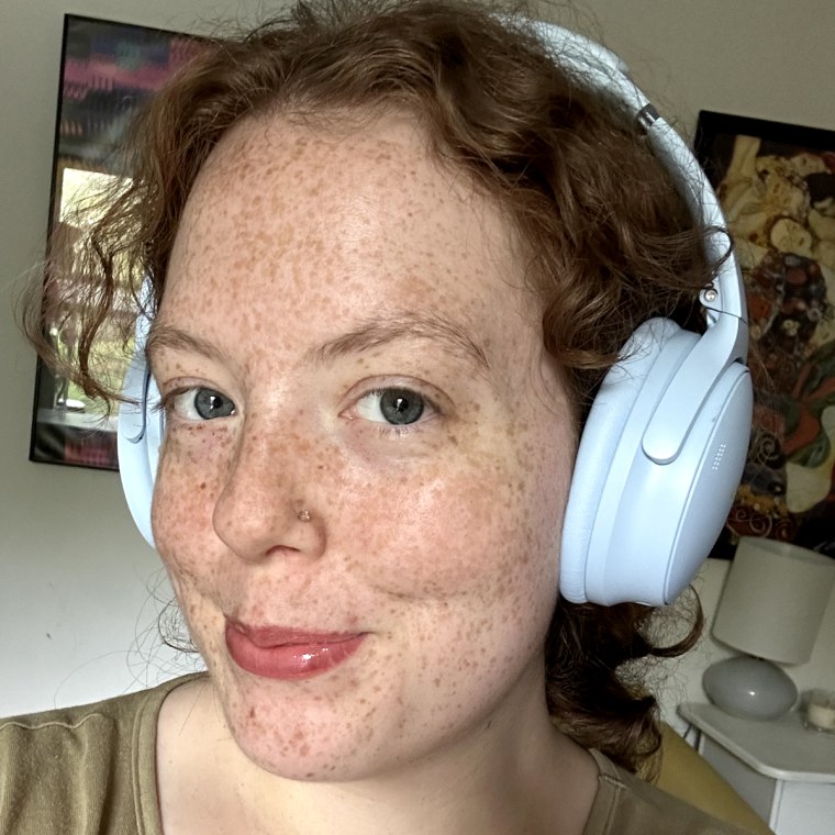 Woman wears light blue Bose QuietComfort Over-Ear Headphones.