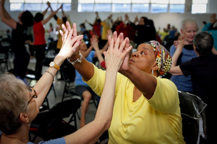 Two women stretch out their arms and hands together