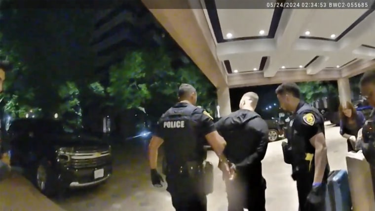 Spadone is taken to a patrol car outside the hotel.