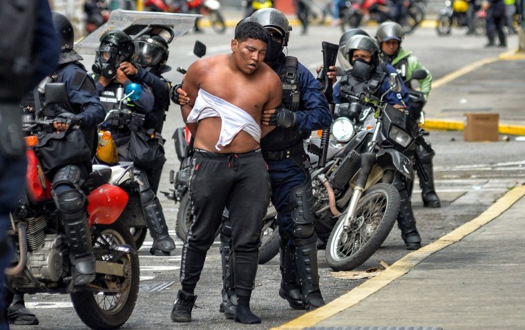 Membros da tropa de choque da Polícia Nacional Bolivariana prendem um manifestante em Caracas, Venezuela