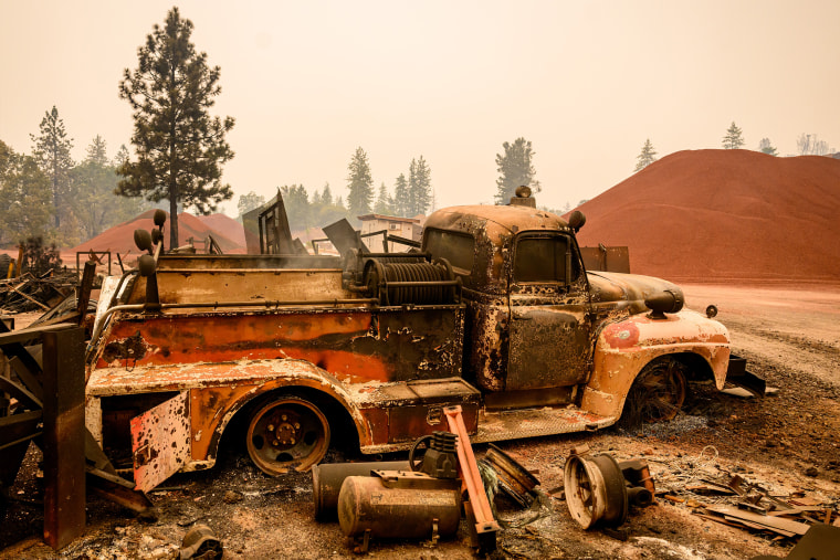 An old fire truck smolders after getting burned during the Park fire in the Paynes Creek area of unincorporated Tehama County, California, on Saturday.