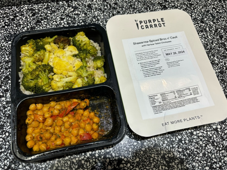 Purple Carrot meal with broccoli, rice, chickpeas and red pepper in a black container on a black and white countertop