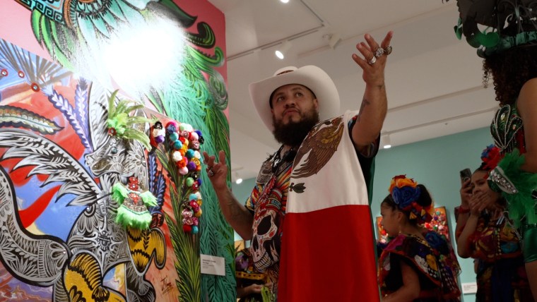 Jose Vera Gonzalez shows off one of his paintings inspired by the Parthenon's collection of pre-Columbian artifacts.