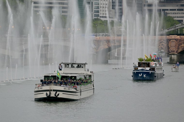 Brazil's delegation sails on a boat in front of a boat with the delegations from Brunei, Bulgaria, Burkina Faso, Burundi and Cape Verde.