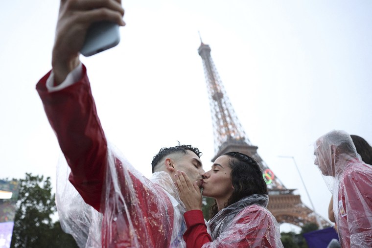 Spain athletes David Vega, left, and Noemi Romero kiss during the opening ceremony for the 2024 Summer Olympics.