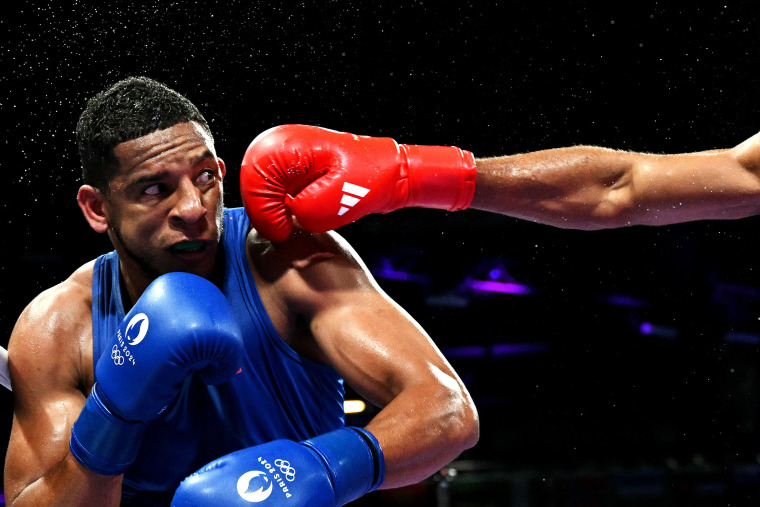 O espanhol Enmanuel Reyes Pla recebe um soco do belga Victor Schelstraete na luta de boxe masculina de 92 kg das quartas de final dos Jogos Olímpicos de Paris 2024, na Arena Norte de Paris, em Villepinte, em 1º de agosto de 2024. 