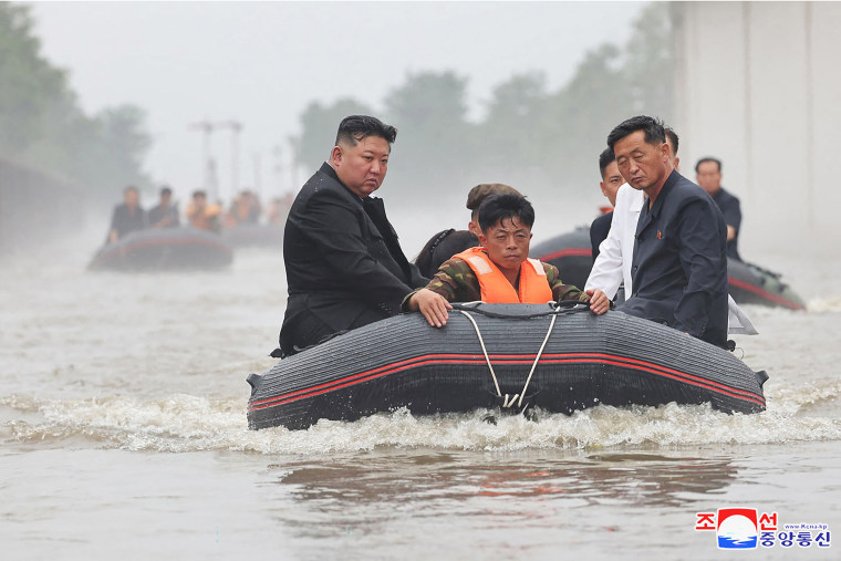 Esta reciente fotografía sin fecha publicada por la Agencia Central de Noticias de Corea del Norte (KCNA) oficial de Corea del Norte a través de KNS el 31 de julio de 2024 muestra al líder de Corea del Norte, Kim Jong Un (izq.), viajando en un bote a través de las aguas de la inundación mientras inspecciona el área en busca de daños después de las fuertes lluvias récord del 29 de julio en la ciudad de Sinuiju en la provincia de Pyongan del Norte.