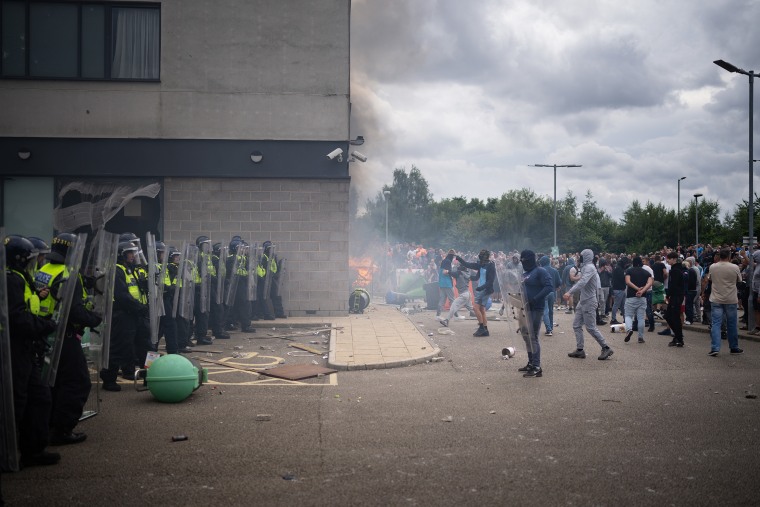 Riot police officers push back anti-migration protesters outside the Holiday Inn Express Hotel which is housing asylum seekers on August 4, 2024 in Rotherham, United Kingdom. 