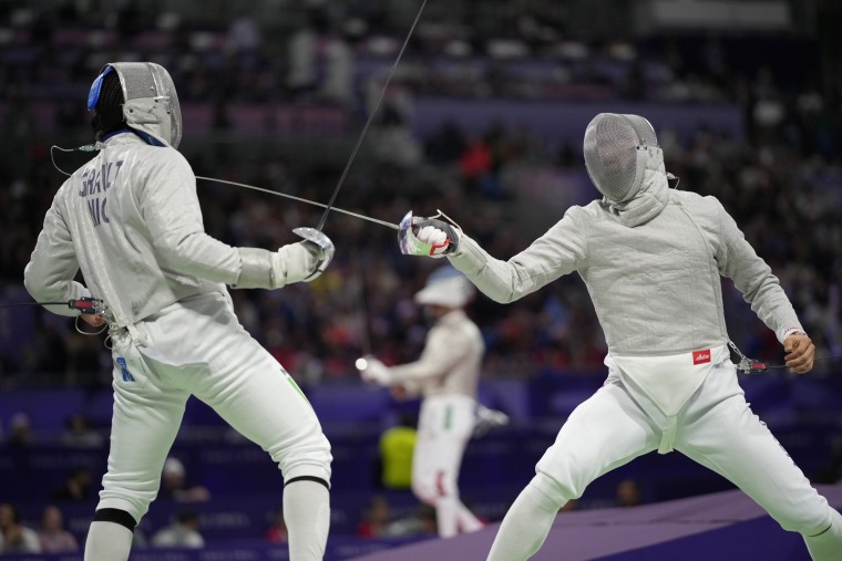 Evann Jean Abba Girault of Niger, left, and Sanguk Oh of South Korea compete in the men's singles saber round on July 27, 2024, in Paris.