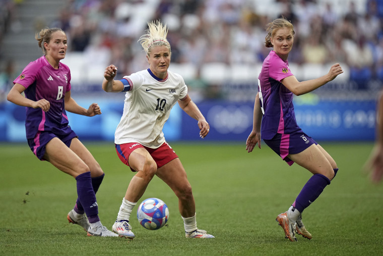 Lindsey Horan fights for the ball with Germany's Sydney Lohmann during a women's semifinal soccer match between the United States and Germany at the 2024 Summer Olympics, Tuesday, Aug. 6, 2024, at Lyon Stadium in Decines, France. 