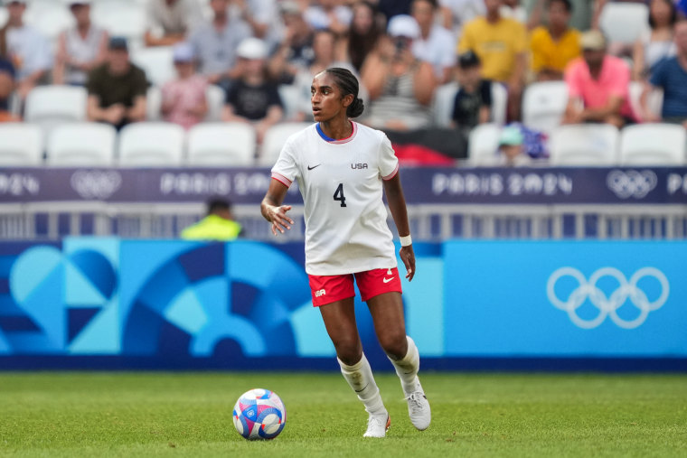 Naomi Girma runs with the soccer ball on the field