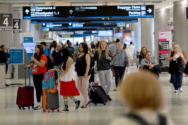 Travelers make their way through the airport