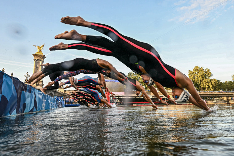 Athletes dive into the Seine river.