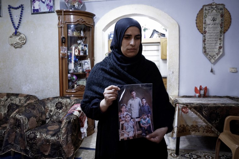 The wife of Palestinian Bilal Saleh shows a picture her late husband in the West Bank village of As-Sawiyah on Nov. 29, 2023.